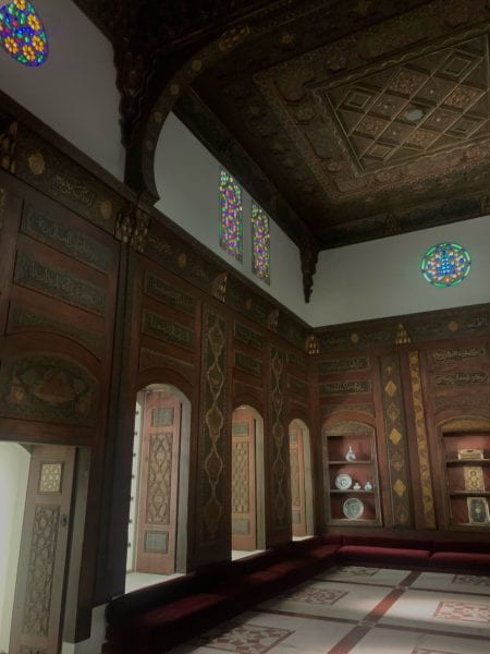 Ornate room with wood inlays and stained glass windows.