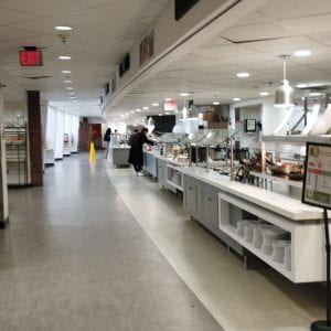 Image of a dining hall, looking down a line of counters and food court areas.