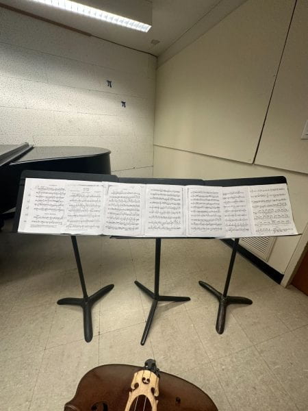 Image of sheet music spread across three music stands.
