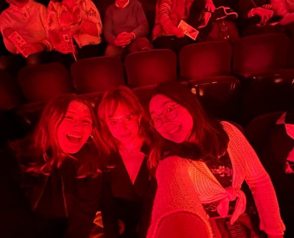 Image of Jade and friends sitting in a theater. 