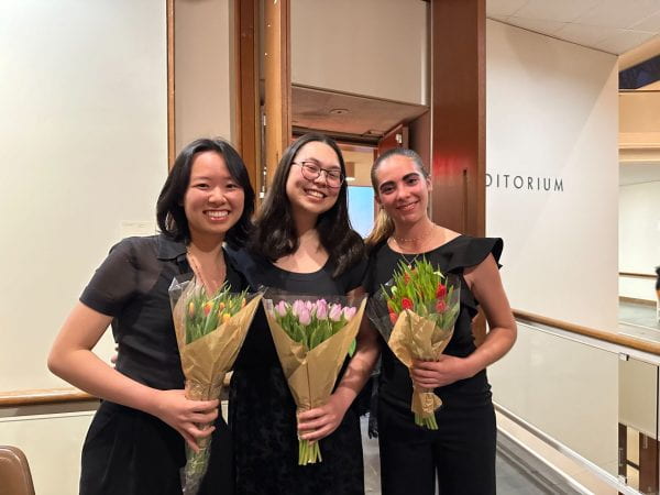 Image of Jade and two friends standing with bouquets of flowers.